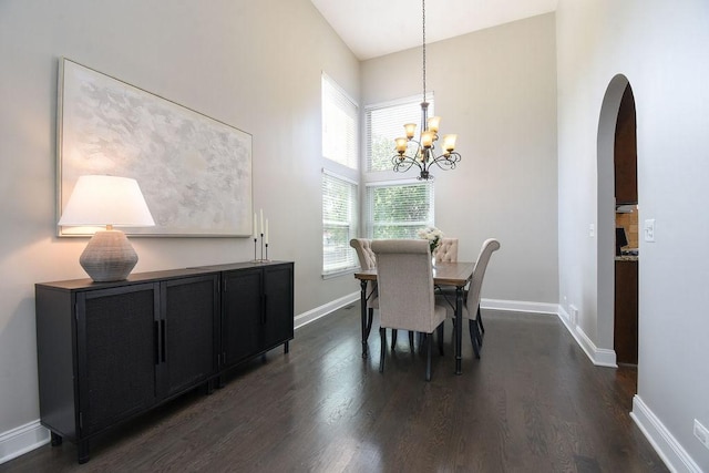 1112 Laurel Ln, Gurnee, IL 60031 - dining space featuring arched walkways, dark wood-type flooring, a towering ceiling, a chandelier, and baseboards