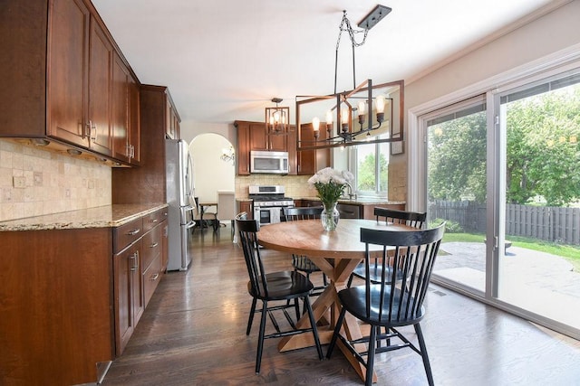 1112 Laurel Ln, Gurnee, IL 60031 - dining area with arched walkways, a chandelier, dark wood-type flooring, and ornamental molding