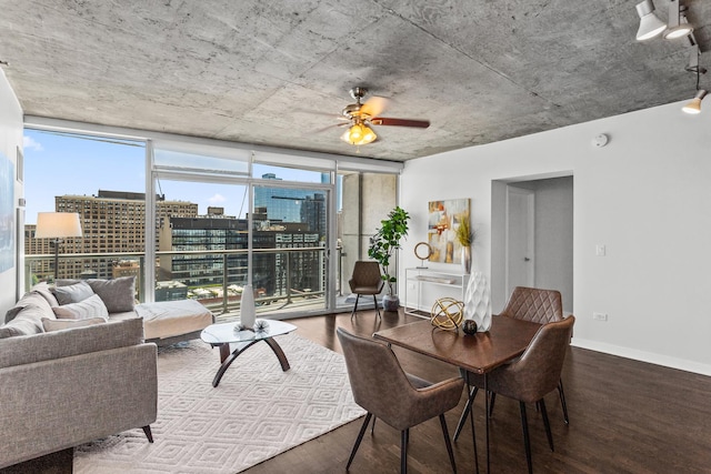 dining space with wood finished floors, healthy amount of natural light, floor to ceiling windows, ceiling fan, and a view of city