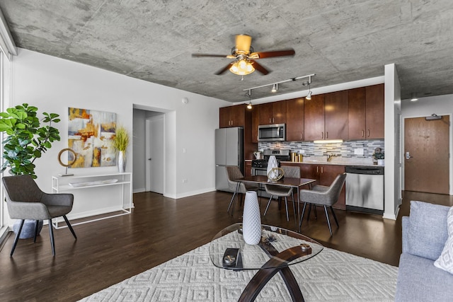 living room with dark wood-style floors, ceiling fan, rail lighting, and baseboards