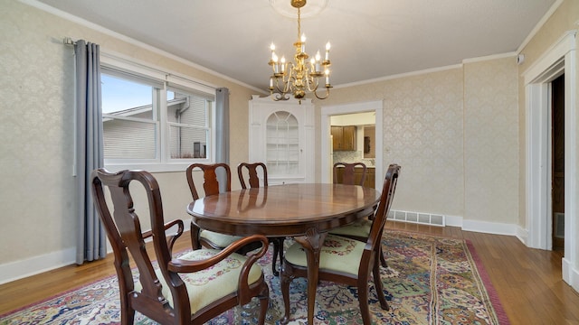 321 E Chamberlin St, Dixon, IL 61021 - dining room featuring a chandelier, crown molding, wood-type flooring, and baseboards