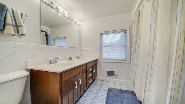 321 E Chamberlin St, Dixon, IL 61021 - bathroom featuring a wainscoted wall, double vanity, and toilet