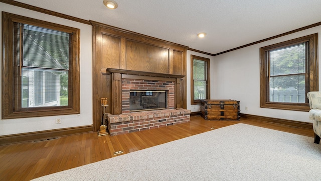 321 E Chamberlin St, Dixon, IL 61021 - living room with ornamental molding, wood finished floors, baseboards, a fireplace, and a textured ceiling