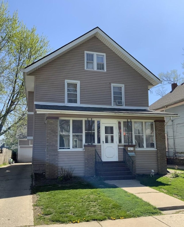 523 Edwards St, Aurora, IL 60505 - american foursquare style home featuring entry steps, a front yard, and brick siding
