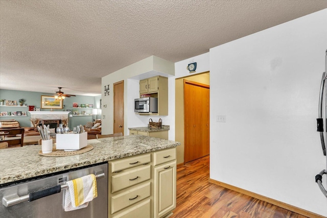 705 Northridge Dr, Mahomet, IL 61853 - kitchen featuring stainless steel appliances, cream cabinets, ceiling fan, light wood finished floors, and a textured ceiling