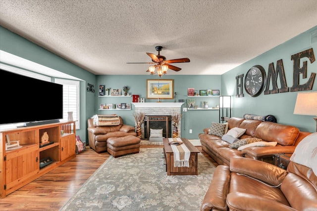 705 Northridge Dr, Mahomet, IL 61853 - living room with wood finished floors, ceiling fan, a textured ceiling, and a brick fireplace