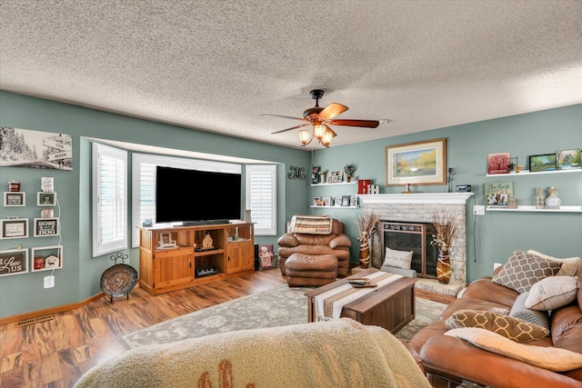 705 Northridge Dr, Mahomet, IL 61853 - living area with ceiling fan, wood finished floors, a brick fireplace, and a textured ceiling