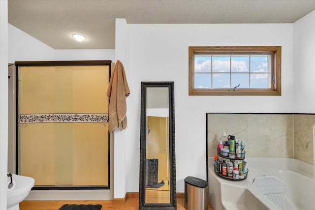 705 Northridge Dr, Mahomet, IL 61853 - full bathroom with a garden tub, a textured ceiling, a shower stall, wood finished floors, and a bidet