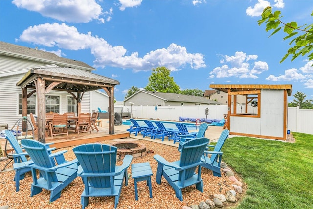 705 Northridge Dr, Mahomet, IL 61853 - fenced backyard featuring a fire pit, a gazebo, a wooden deck, a pool, and outdoor dining area