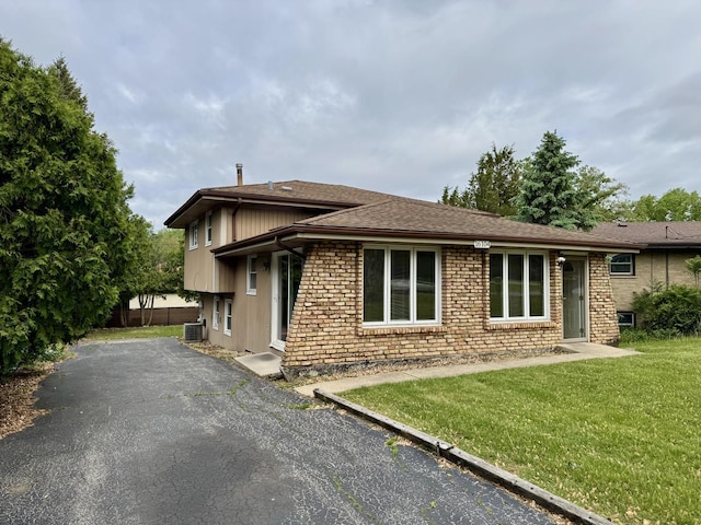 16104 Oak Ave, Oak Forest, IL 60452 - view of front of property with a front yard, roof with shingles, cooling unit, and brick siding
