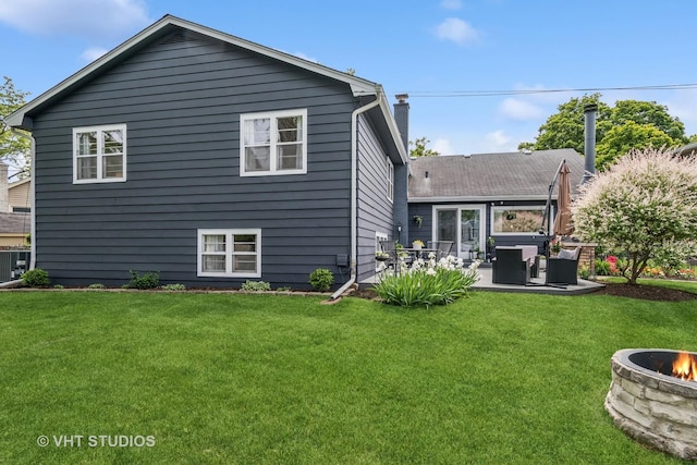 1140 Catalpa Ln, Naperville, IL 60540 - back of house featuring a patio area, a lawn, a chimney, central AC unit, and an outdoor living space with a fire pit