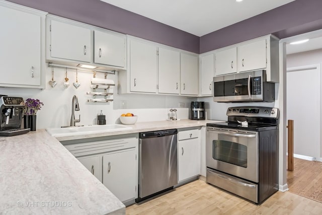 1140 Catalpa Ln, Naperville, IL 60540 - kitchen with stainless steel appliances, a sink, light countertops, and white cabinetry