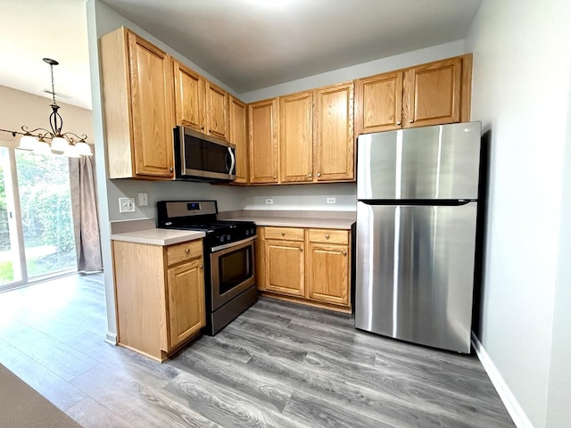 4078 Boulder Ct, Aurora, IL 60504 - kitchen featuring appliances with stainless steel finishes, light wood-type flooring, light countertops, a chandelier, and baseboards