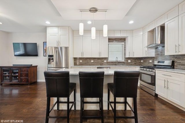 3019 N Allen Ave, Chicago, IL 60618 - kitchen featuring stainless steel appliances, wall chimney exhaust hood, backsplash, a center island, and a kitchen breakfast bar