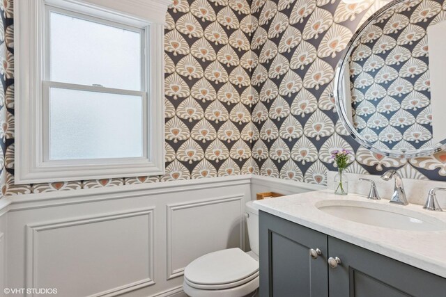 2450 W Warner Ave, Chicago, IL 60618 - half bathroom with a decorative wall, vanity, toilet, and wainscoting