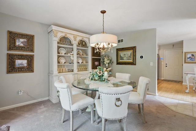 36 Lakewood Cir, Saint Charles, IL 60174 - dining area featuring light carpet, a chandelier, baseboards, and light tile patterned floors