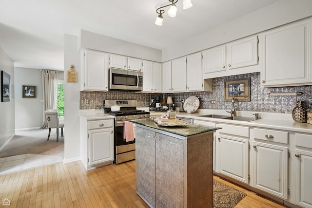36 Lakewood Cir, Saint Charles, IL 60174 - kitchen featuring stainless steel appliances, a sink, a center island, white cabinetry, and backsplash