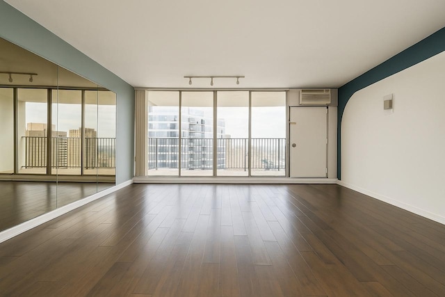 300 N State St Unit 5503, Chicago, IL 60654 - empty room featuring rail lighting, dark wood-type flooring, baseboards, and plenty of natural light