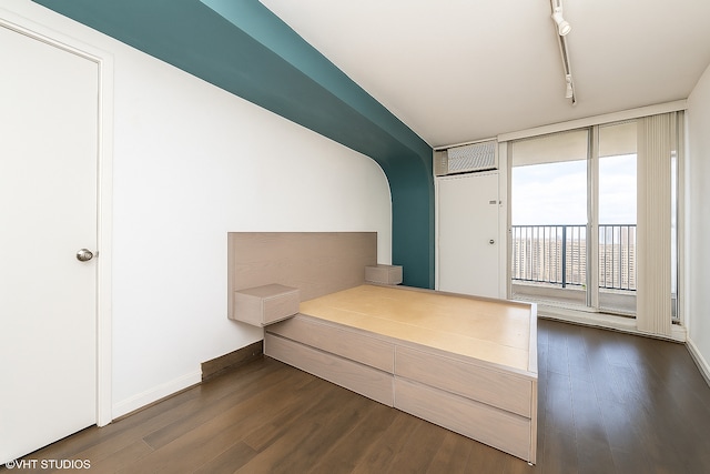 300 N State St Unit 5503, Chicago, IL 60654 - unfurnished bedroom featuring access to exterior, dark wood-type flooring, track lighting, and baseboards