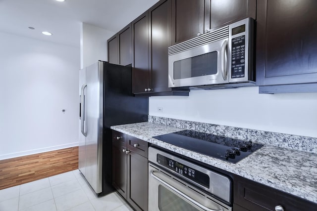 737 W Washington Blvd Unit 2702, Chicago, IL 60661 - kitchen featuring appliances with stainless steel finishes, light tile patterned flooring, dark brown cabinets, recessed lighting, and light stone countertops