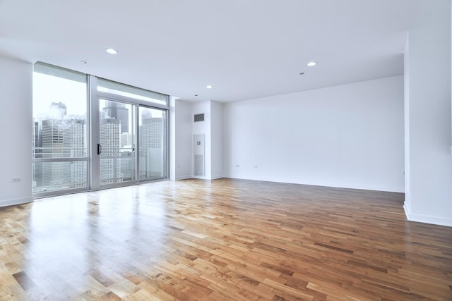 737 W Washington Blvd Unit 2702, Chicago, IL 60661 - spare room with wood finished floors, floor to ceiling windows, recessed lighting, and baseboards