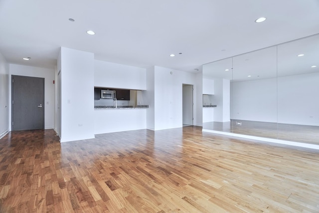 737 W Washington Blvd Unit 2702, Chicago, IL 60661 - unfurnished living room featuring wood finished floors, recessed lighting, baseboards, and a sink