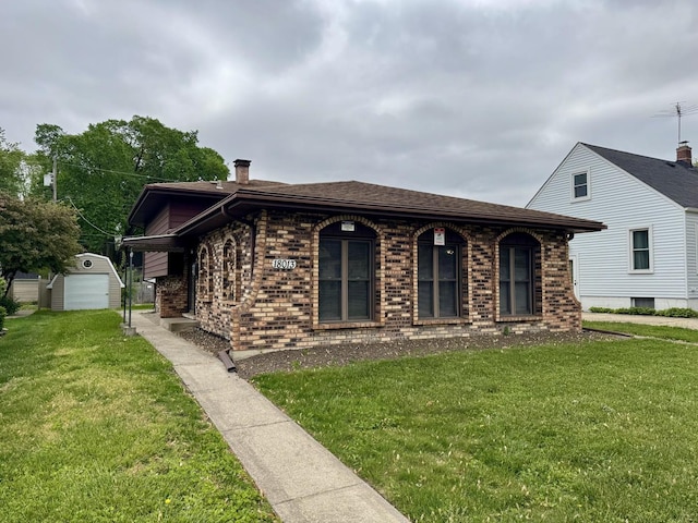 18013 Park Ave, Lansing, IL 60438 - view of front of property with brick siding, a front yard, an outdoor structure, a shingled roof, and a chimney