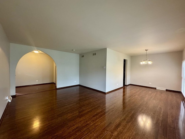 18013 Park Ave, Lansing, IL 60438 - spare room featuring wood finished floors, a chandelier, baseboards, and arched walkways
