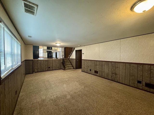 18013 Park Ave, Lansing, IL 60438 - empty room featuring wainscoting, stairs, wood walls, and light colored carpet
