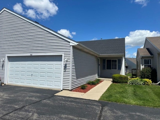 view of front facade with driveway, a garage, and a front lawn