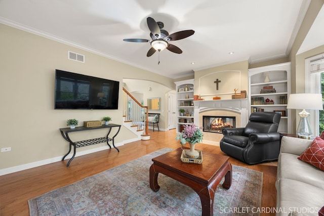 203 E Lincoln Ave, Wheaton, IL 60187 - living area featuring ceiling fan, a multi sided fireplace, wood finished floors, stairway, and crown molding