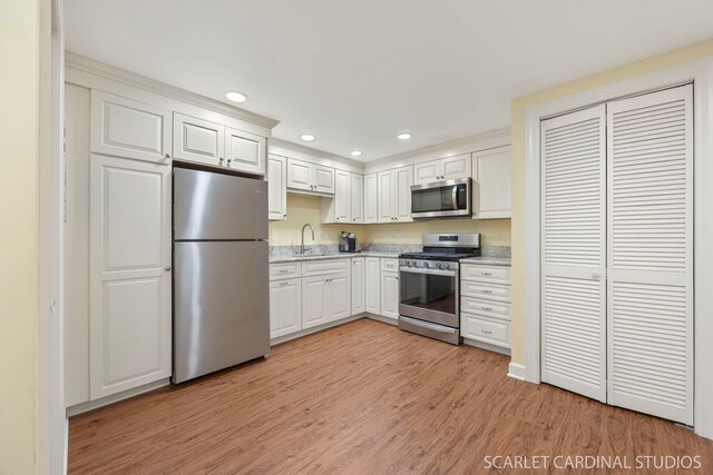 203 E Lincoln Ave, Wheaton, IL 60187 - kitchen with appliances with stainless steel finishes, a sink, light wood-style flooring, recessed lighting, and white cabinetry