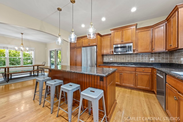 203 E Lincoln Ave, Wheaton, IL 60187 - kitchen featuring stainless steel appliances, light wood-type flooring, brown cabinets, backsplash, and crown molding