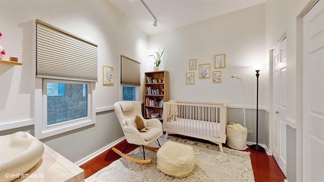 1508 Elmwood Ave Unit 3, Evanston, IL 60201 - bedroom with wood finished floors, a crib, track lighting, and baseboards
