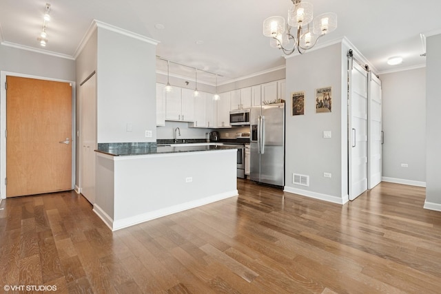 421 W Huron St Unit 1503, Chicago, IL 60654 - kitchen with stainless steel appliances, a sink, dark countertops, wood finished floors, and white cabinetry