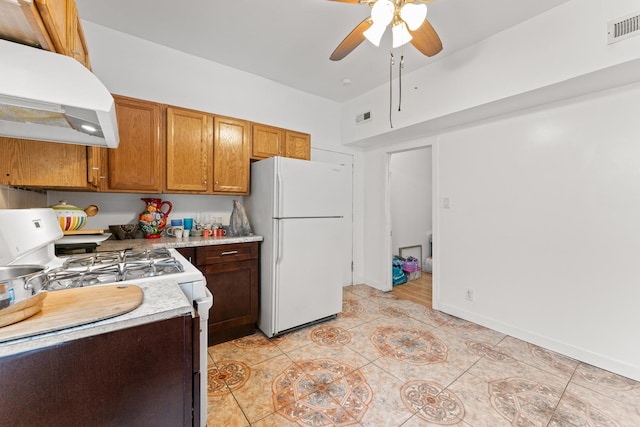 4947 W Huron St, Chicago, IL 60644 - kitchen with white appliances, under cabinet range hood, a ceiling fan, light countertops, and brown cabinets