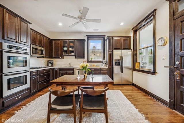 4940 N Ridgeway Ave Unit 3, Chicago, IL 60625 - kitchen featuring appliances with stainless steel finishes, dark brown cabinetry, a sink, light wood-type flooring, and light countertops