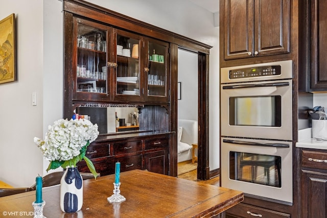 4940 N Ridgeway Ave Unit 3, Chicago, IL 60625 - kitchen with double wall oven, dark brown cabinets, and glass insert cabinets