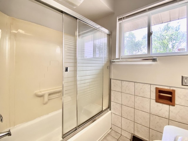 664 E 163rd St, South Holland, IL 60473 - bathroom featuring tile walls, combined bath / shower with glass door, plenty of natural light, tile patterned floors, and wainscoting