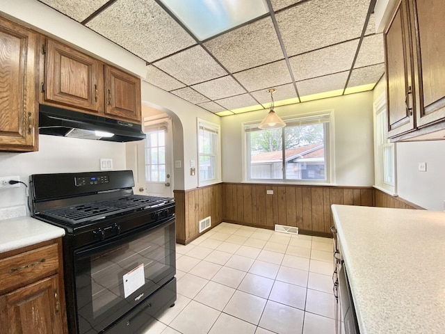 664 E 163rd St, South Holland, IL 60473 - kitchen with gas stove, a wainscoted wall, under cabinet range hood, arched walkways, and light countertops