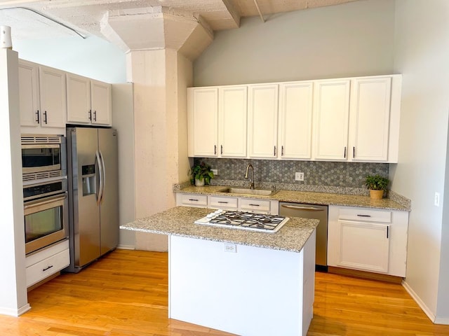 1530 S State St Unit 525, Chicago, IL 60605 - kitchen with stainless steel appliances, a sink, backsplash, vaulted ceiling, and light wood-style floors