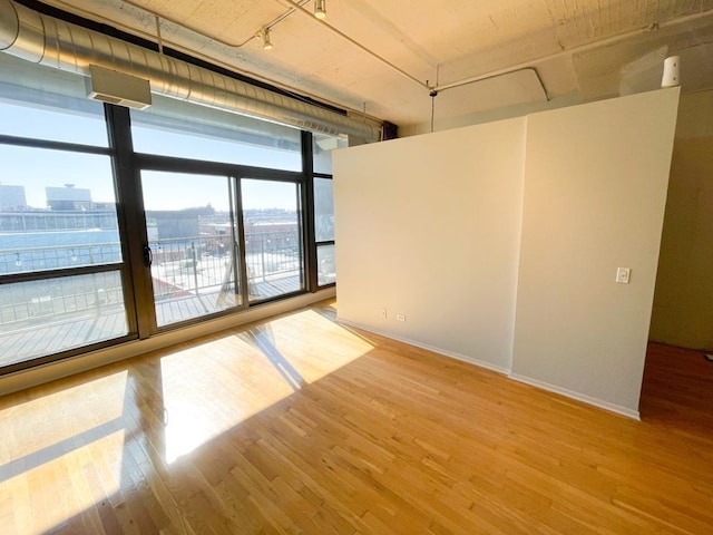 1530 S State St Unit 525, Chicago, IL 60605 - spare room featuring baseboards, light wood-style floors, floor to ceiling windows, rail lighting, and a city view