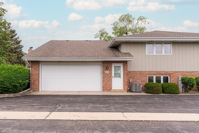 18207 Ohio Ct, Orland Park, IL 60467 - split level home featuring brick siding, a shingled roof, a chimney, and central air condition unit