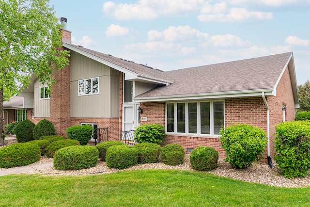 18207 Ohio Ct, Orland Park, IL 60467 - tri-level home with a chimney, brick siding, a shingled roof, and a front yard