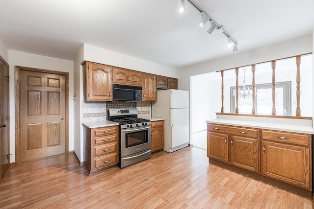 18207 Ohio Ct, Orland Park, IL 60467 - kitchen with stainless steel gas range oven, black microwave, freestanding refrigerator, light countertops, and light wood-style floors