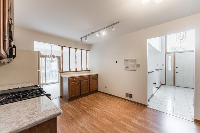 18207 Ohio Ct, Orland Park, IL 60467 - kitchen with a chandelier, light countertops, brown cabinets, and light wood-type flooring