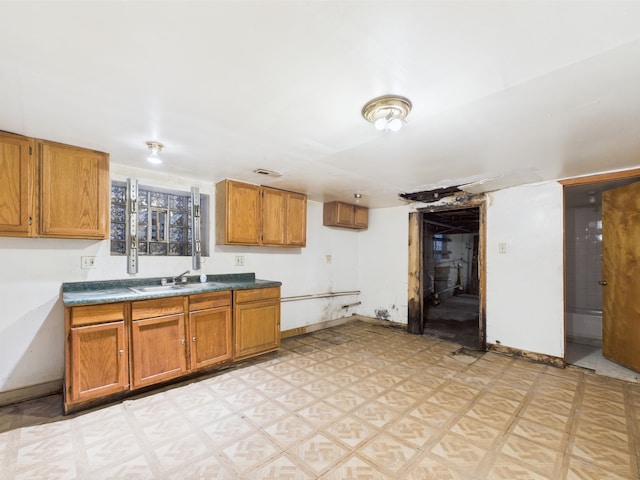 8237 S Ada St, Chicago, IL 60620 - kitchen with a sink, brown cabinetry, light floors, and baseboards