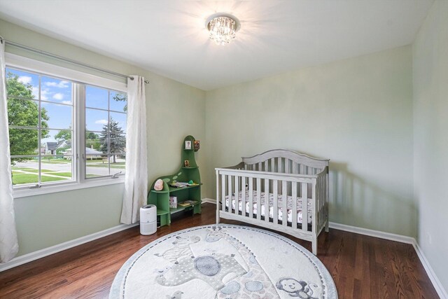 4647 N Thatcher Ave, Norridge, IL 60706 - bedroom with wood finished floors, baseboards, a chandelier, and a nursery area