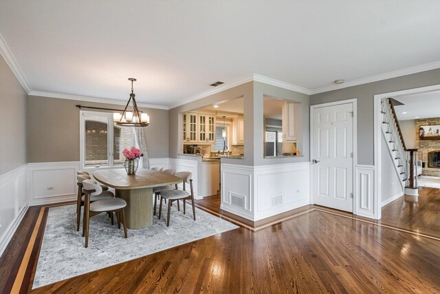 4647 N Thatcher Ave, Norridge, IL 60706 - dining room with dark wood-type flooring, wainscoting, a chandelier, and crown molding