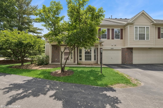 1087 Huntwyck Ct, Elgin, IL 60120 - multi unit property with driveway, brick siding, an attached garage, and a front lawn